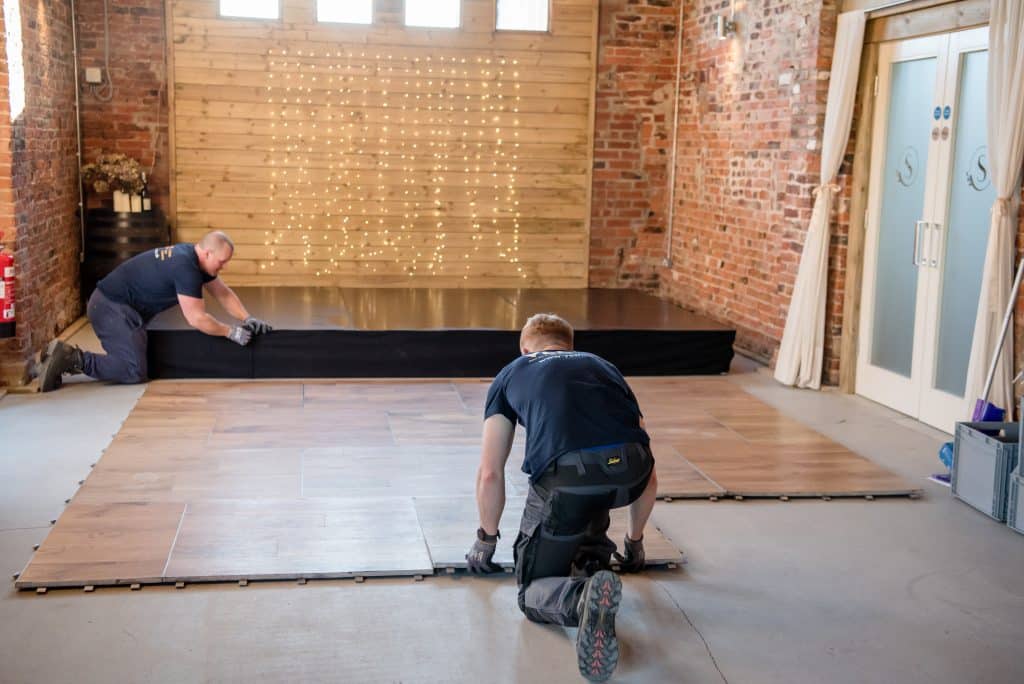 Two staff from YES Hire lay an oak Dance floor at Sedgewell Barns in Northallerton