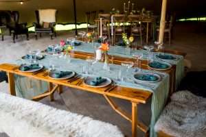 A rustic table set with fine dining plates, champagne saucers and water glasses. This was on hire in Catton.
