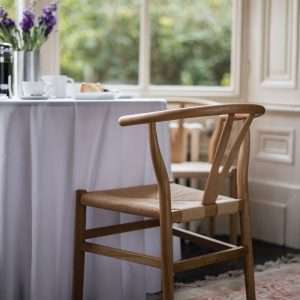 YES Hire's Wishbone Chair's next to a small round table in the window