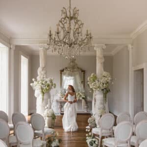 A bride walking down a ceremony space at Forcett Hall. the hall is set with YES Hire's Louis Chairs