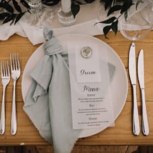Two course cutlery set next to a white plate with a napkin